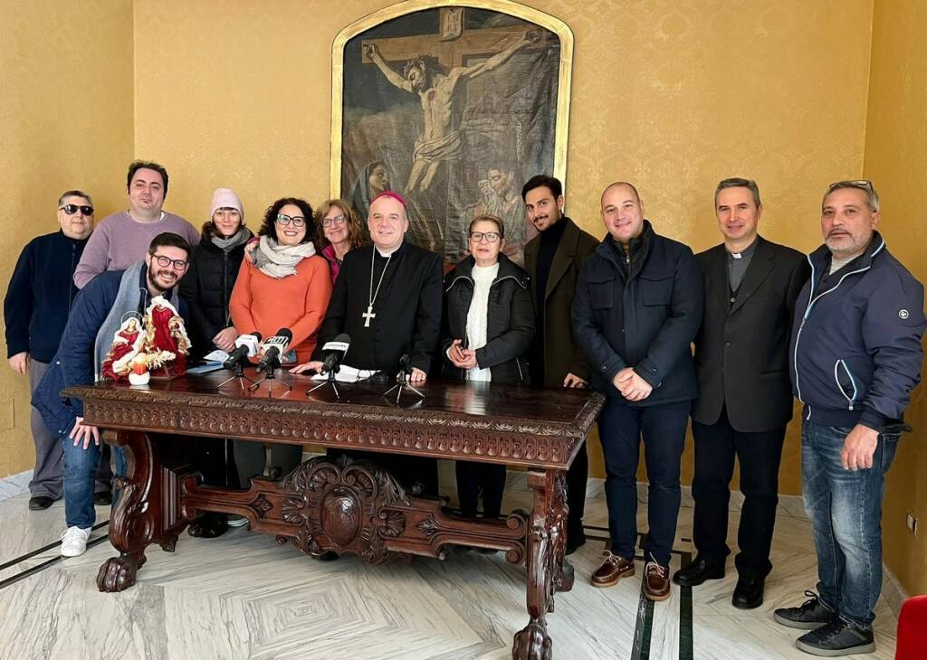 Foto di gruppo con giornalisti e cineoperatori al termine della conferenza stampa, al centro il vescovo Panzetta