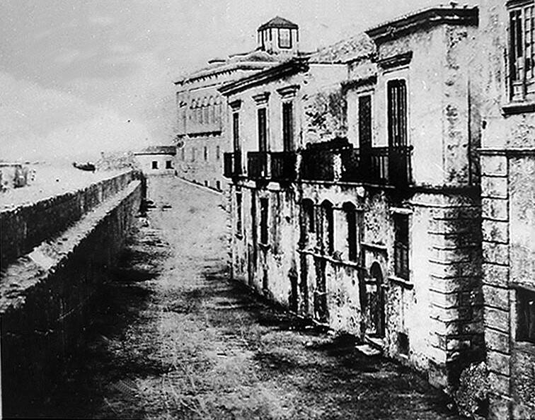 Crotone, la cortina spagnola nei primi del Novecento davanti a palazzo Fonte-Calojro nel rione Pescheria; in basso a sinistra vico Orfeo, in fondo palazzo Giunti